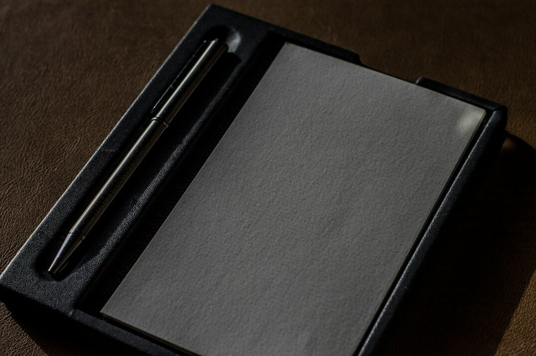 Close-up of a reporter's notebook and pen on a wooden desk